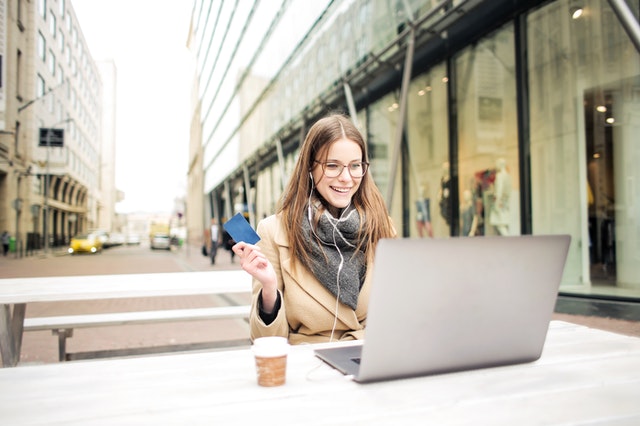Happy woman in brown coat online shopping Happy woman in brown coat online shopping