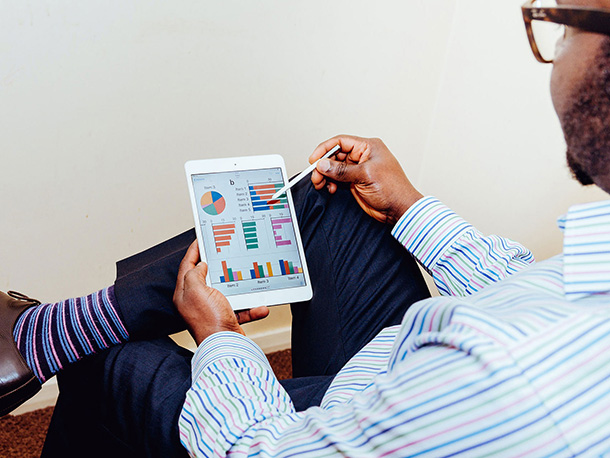 Man Analyzing his investments on a tablet Man in business casual clothing Analyzing his investments on a tablet