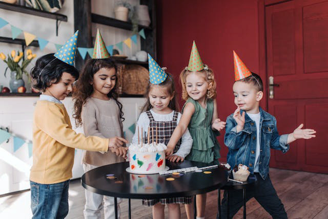 Kids celebrating wearing birthday hats and eating cake Kids celebrating wearing birthday hats and eating cake