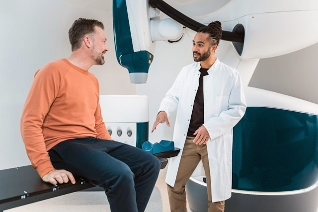 Man in a doctor's office talking to a doctor happily Man in a doctor's office talking to a doctor happily