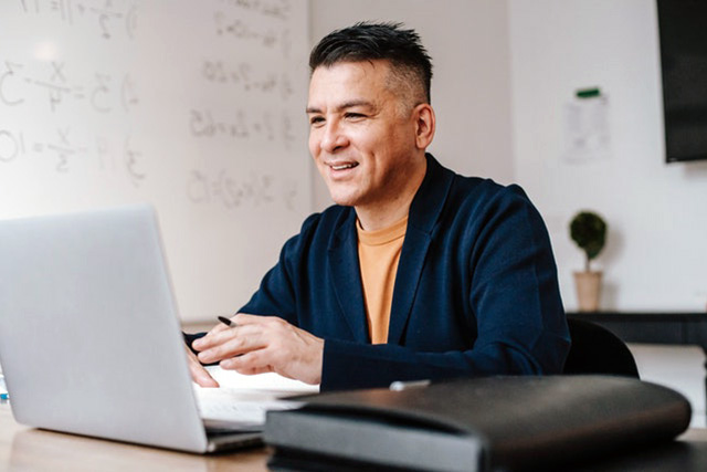 Man looking at his laptop smiling