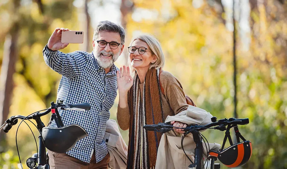 Smiling couple taking a selfie next to their bikes on a Michigan fall day.